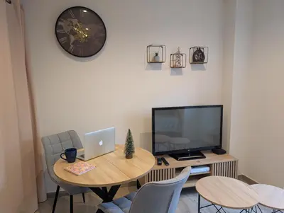 a room with a table with a laptop and a tv at Le Cocon de Pezens - Studio au centre du village in Pezens