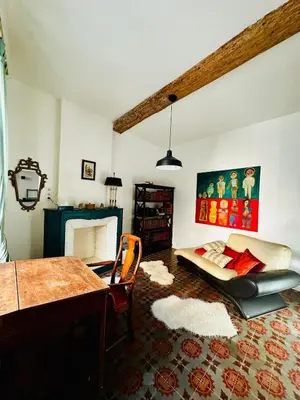a living room with a table and a couch at Maison de village avec piscine 8 personnes in Ouveillan