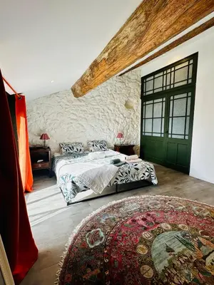 a bedroom with two beds and a green door at Maison de village avec piscine 8 personnes in Ouveillan