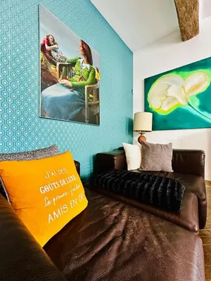 a living room with a couch and a painting on the wall at Maison de village avec piscine 8 personnes in Ouveillan