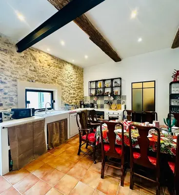 a kitchen and dining room with a table and chairs at Maison de village avec piscine 8 personnes in Ouveillan
