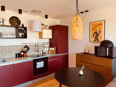 a kitchen with red cabinets and a table at Plein Soleil in Félines-Minervois