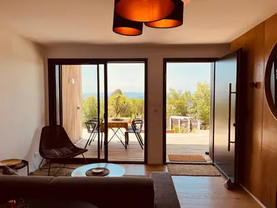 a living room with a sliding glass door to a patio at Plein Soleil in Félines-Minervois