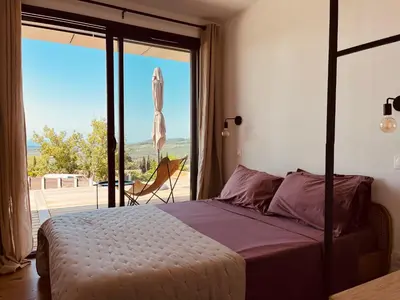 a bedroom with a bed and a view of a patio at Plein Soleil in Félines-Minervois