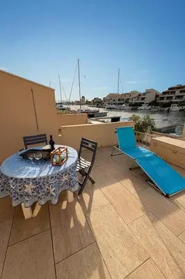 a patio with a table and chairs on a roof at Marina au bord de l'eau accès direct port in Gruissan