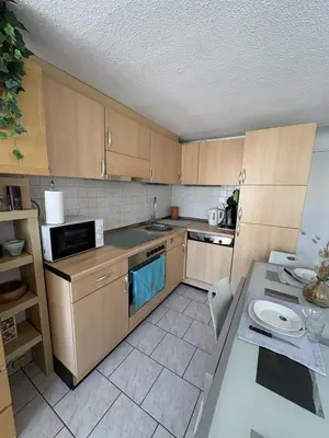 a small kitchen with wooden cabinets and a table at Marina au bord de l'eau accès direct port in Gruissan