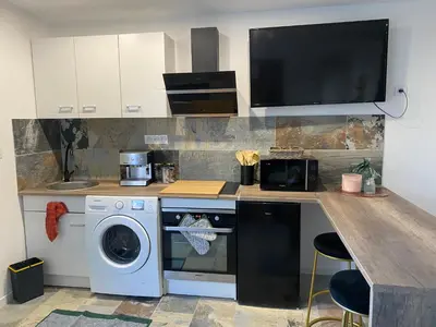 a kitchen with a washing machine and a counter with a sink at Studio climatisé avec terrasse in Narbonne