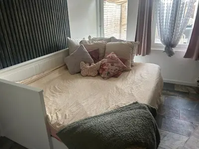 a bed with pillows on it in a room at Studio climatisé avec terrasse in Narbonne