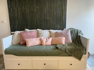 a couch with many pillows on top of it at Studio climatisé avec terrasse in Narbonne
