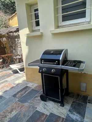 a barbecue grill sitting on a patio next to a building at Studio climatisé avec terrasse in Narbonne