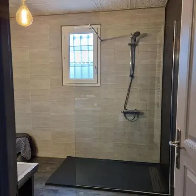 a shower in a bathroom with a window at villa familiale piscine privé sans vis à vis in Bages