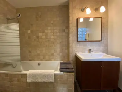 a bathroom with a tub and a sink and a mirror at Gite La Grange, climatisée, vue sur le château de Peyrepertuse in Rouffiac-des-Corbières
