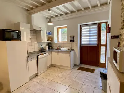 a kitchen with white appliances and a door at Gite La Grange, climatisée, vue sur le château de Peyrepertuse in Rouffiac-des-Corbières