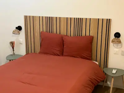 a bedroom with a red bed with two tables at Le Loft du Canal du midi & son garage Vélos-Capestang in Capestang