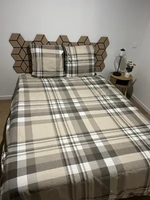 a bed with a plaid blanket on top of it at Le Loft du Canal du midi & son garage Vélos-Capestang in Capestang