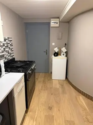 a kitchen with a stove and a refrigerator at Appartement détente dans les corbières in Conilhac-Corbières