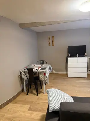 a living room with a table and a tv at Appartement détente dans les corbières in Conilhac-Corbières