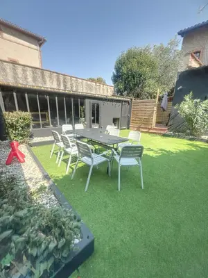 a patio with a table and chairs on the grass at Day rental for Family Reunion, Anniv in Mazères