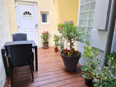 a patio with plants and a chair and a door at La parenthèse Carcassonnaise - 4 voyageurs - Terrasse - Proche cité médiévale in Carcassonne
