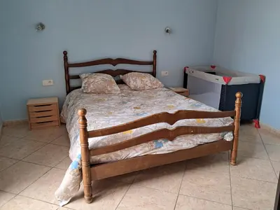 a bedroom with a bed with a wooden frame at Villa Pierrot in Portel-des-Corbières