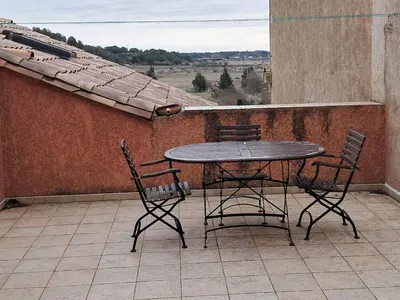 a table and chairs on a balcony with a view at Villa Pierrot in Portel-des-Corbières