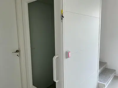 a white refrigerator in a room next to a door at Entre sel et ciel 2 maisons 2 caractères 1 piscine 1 boulodrome 2 ascenseurs in Peyriac-de-Mer