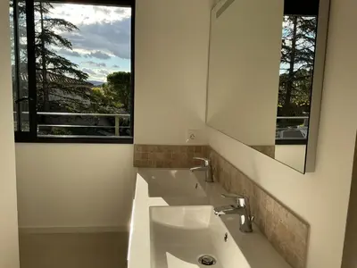 a bathroom with two sinks and a mirror and a window at Entre sel et ciel 2 maisons 2 caractères 1 piscine 1 boulodrome 2 ascenseurs in Peyriac-de-Mer