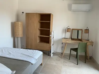 a bedroom with a bed and a desk with a mirror at Entre sel et ciel 2 maisons 2 caractères 1 piscine 1 boulodrome 2 ascenseurs in Peyriac-de-Mer