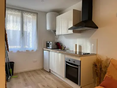 a small kitchen with white cabinets and a stove at Charmant Studio Narbonnais in La Celle-sous-Gouzon
