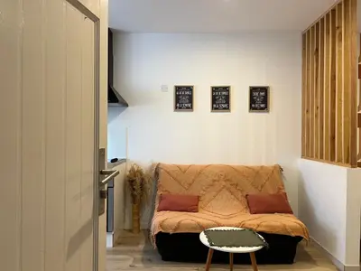 a small bedroom with a bed and a stool at Charmant Studio Narbonnais in La Celle-sous-Gouzon