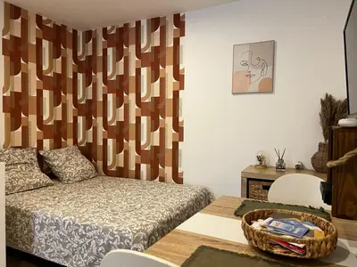 a bedroom with a bed and a table with a basket at Charmant Studio Narbonnais in La Celle-sous-Gouzon