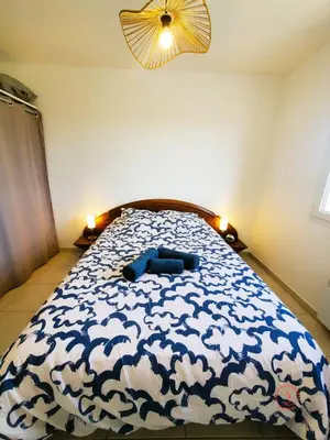 a bedroom with a bed with a blue pillow on it at La Saline maison familiale avec jardin in Lapalme