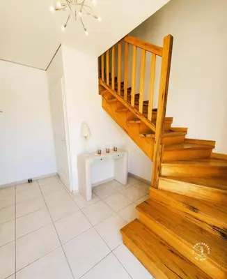 a living room with a staircase and a table at La Saline maison familiale avec jardin in Lapalme