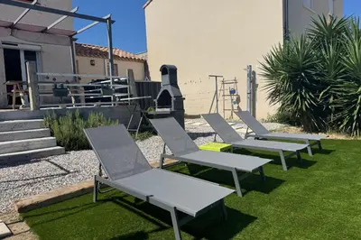 a row of lawn chairs sitting on the grass at La Saline maison familiale avec jardin in Lapalme