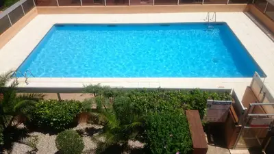 an overhead view of a large blue swimming pool at Studio à deux pas du port avec piscine in Gruissan