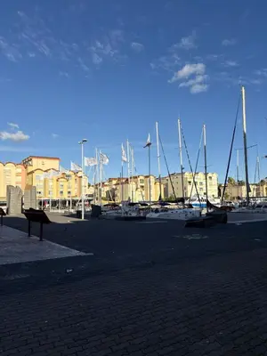 a marina with sail boats in a harbor with buildings at Studio à deux pas du port avec piscine in Gruissan