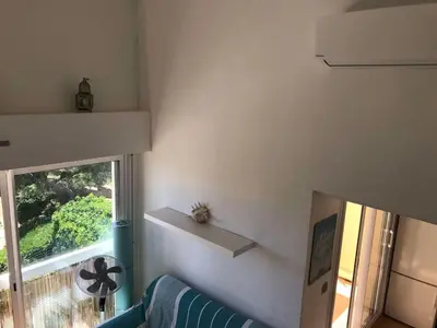a living room with a blue couch and a window at Appartement cosy vue mer avec terrasse in Gruissan