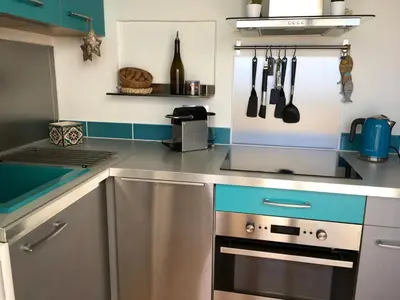 a kitchen with a stainless steel stove top oven at Appartement cosy vue mer avec terrasse in Gruissan