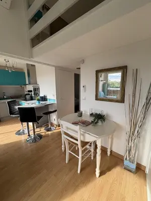 a living room with a white table and a mirror at Appartement cosy vue mer avec terrasse in Gruissan