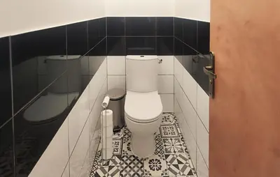 a bathroom with a toilet in a black and white tiles at Gorgeous Home In Villespassans in Villespassans