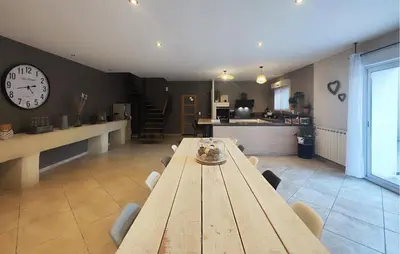 a dining room with a table and a clock on the wall at Stunning Home In Puisserguier in Puisserguier