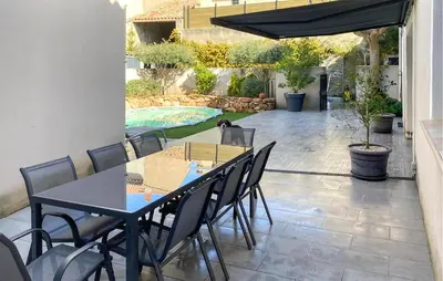 a patio with a table and chairs and a pool at Stunning Home In Puisserguier in Puisserguier
