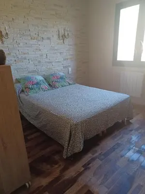 a bed in a room with a brick wall at Maison Sol Air in Montazels