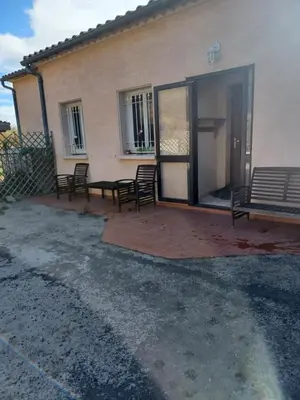 a patio with chairs and a bench in front of a building at Maison Sol Air in Montazels