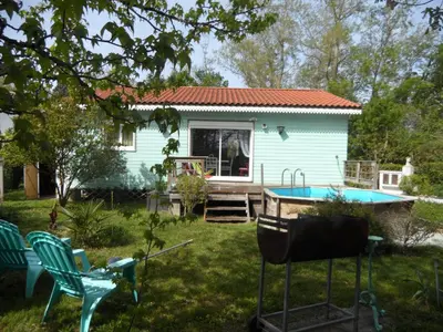 a small blue house with a pool in the yard at Maison dans un écrin de verdure in Sorèze