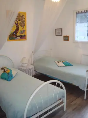 two twin beds in a room with a window at Maison dans un écrin de verdure in Sorèze