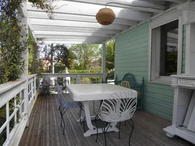 a white table and chairs on the porch of a house at Maison dans un écrin de verdure in Sorèze