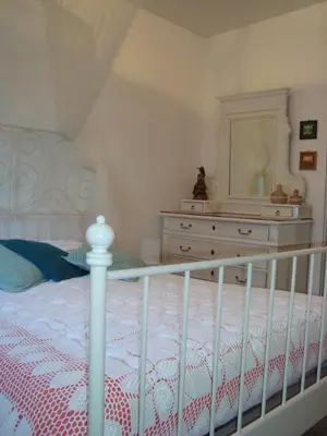 a bedroom with a bed with a dresser and a mirror at Maison dans un écrin de verdure in Sorèze