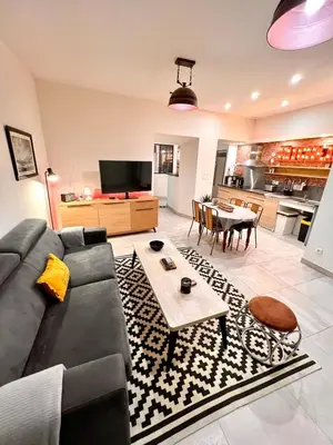 a living room with a couch and a table at Loft jacuzzi à 8 min des Grands Buffets et du centre-ville in Narbonne