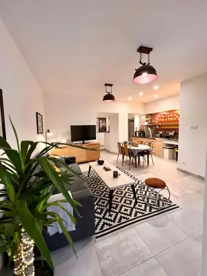 a living room with a couch and a table at Loft jacuzzi à 8 min des Grands Buffets et du centre-ville in Narbonne